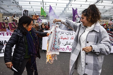 FILE - Iranian women burn their headscarves during a rally against the death of Iranian Mahsa Amini in Bern, Switzerland, Sept. 27, 2022. (Photo |AP)