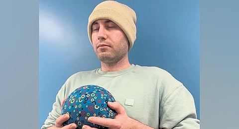 Computer scientist Alexz Farrall holds the Physical Artefact for Well-being Support (PAWS) ball. (Photo | Express)