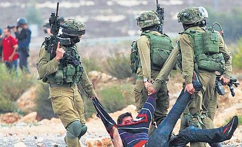 Israeli soldiers capture a Palestinian protestor during a conflict