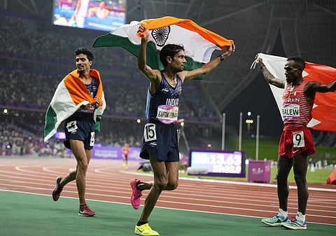 Bronze medalist Gulveer Singh (L) and silver medalist Kartik Kumar (C) celebrate after the men's 10000-meter final at the 19th Asian Games in Hangzhou, Sept. 30, 2023. (Photo | AP)
