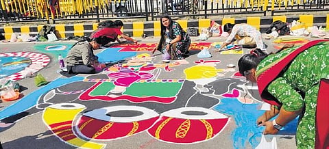 Artists participating in Rangoli Mahotsav themed on Dhanuyatra in front of Women’s College to Gourpada in Bargarh Town. (Photo | Express)