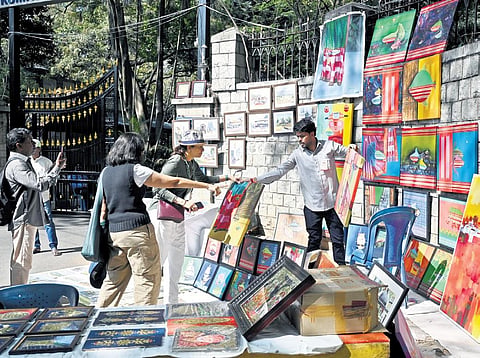 An artist displays his works at the 21st Chitra Santhe on Sunday | nagaraja Gadekal