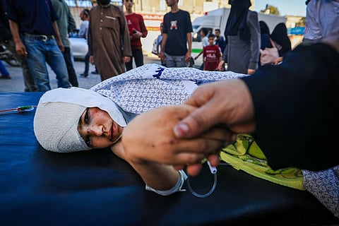 A mother comforts her child, who was wounded in a strike, at Nasser Hospital in Khan Yunis on the southern Gaza Strip on October 20, 2023. (Photo | AFP)