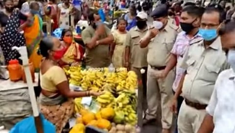 मासळी मार्केट जवळ फळविक्रेत्यांना सुचना करताना पोलिस व पालिका कर्मचारी.