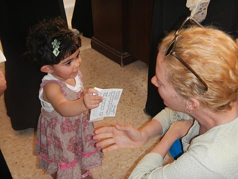 A toddler holding her immunisation card. Credit: CDC Global / Flickr