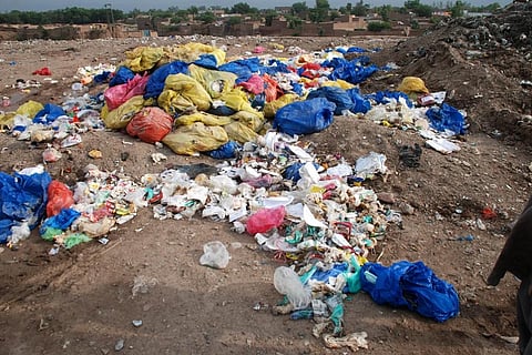 Trash, including hospital waste, is lying in the open in Aftab Abad where dwellers have forcibly stopped WSSP from dumping of solid waste due to proximity of the site with population. Credit: Adeel Saeed