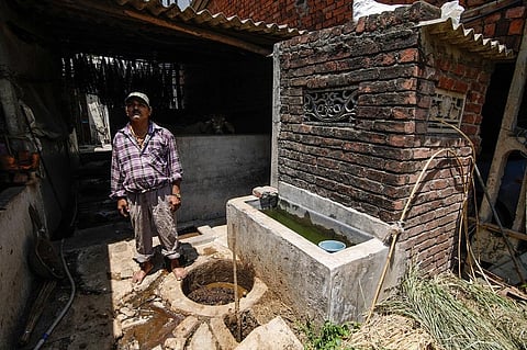 A villager standing next to a toilet-linked biogas plant in Valsad, Gujarat. Photo: Vikas Choudhary