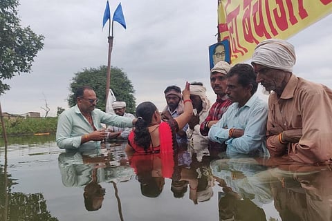 पानी में खड़े होकर ओंकारेश्वर बांध का विरोध कर रहे आंदोलनकारियों को उनकी बहनों ने पानी में घुसकर भैया दूज मनाया। फोटो: एनबीए