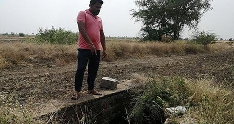 Engineer-turned- farmer Mahantesh Nagaral showing the small well through which water flows into the adjoining field after the soil has soaked up enough moisture. Photo: Akshit Sangomla