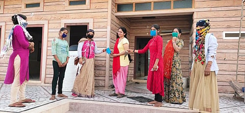 मास्क वितरित करती किशोरियां। फोटो: चरखा फीचर्स