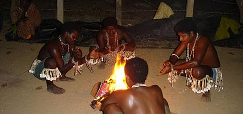 Great Andamanese boys squatting around a fire. Photo: Anvita Abbi