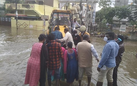 An earth mover rescues a family stranded due to floods in Malkajgiri: Telangana has received extremely heavy rainfall since October 13. Photo: Rachakonda Police @RachakondaCop / Twitter