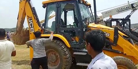 Locals damaging an earth-moving machine in Odisha's Bharigada village. Photo: Ashis Senapati