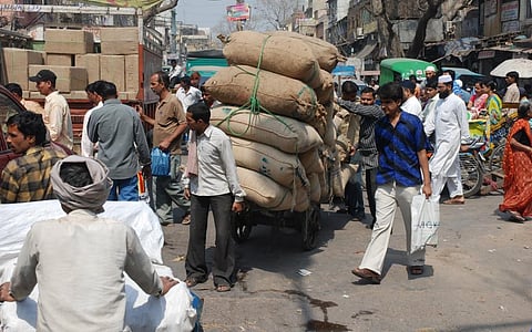 A man ferrying grain at Lahori Gate, Delhi. Photo: Agnimirh Basu / CSE