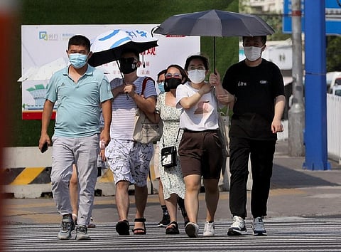 People useing umbrellas to shield themselves from the heatwave (Photo: China Xinhua News)