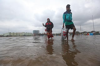 People walking through the flooded shores of Marina Beach in Chennai in the aftermath of Cyclone Mandous. Photo: picschennai