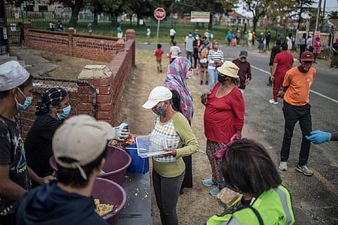 A charity in Westbury, Johannesburg, hands out food parcels during the COVID pandemic in 2020. Photo: Marco Longari/AFP via Getty Images.