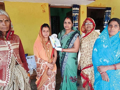 मध्य प्रदेश के छिंदवाड़ा जिले की मऊ गांव के प्रेरणा स्वयं सहायता समूह की महिलाएं पानी की गुणवत्ता का मानक दिखाती हुईं (फोटो: रूबी सरकार)
