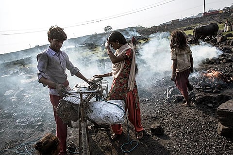 धनबाद के झरिया में अपनी साइकिलों पर कोयला लादते स्थानीय ग्रामीण; फोटो: आईस्टॉक