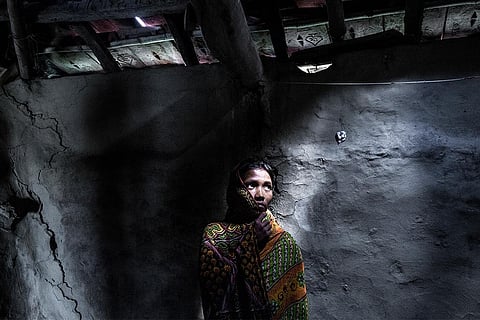 समुद्र के बढ़ते जल स्तर से क्षतिग्रस्त अपने घर के सामने खड़ी 25 वर्षीय महिला; फोटो: सुप्रतिम भट्टाचार्य/ आईस्टॉक