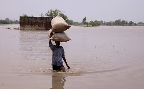 भारी बारिश और बाढ़ के बाद अपने साधनों को सुरक्षित करने का प्रयास करता किसान; फोटो: आईस्टॉक