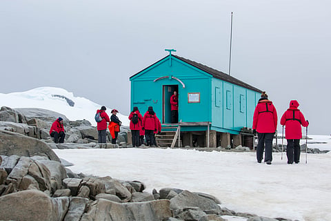 Tourists at the historic Damoy Hut, a scientific research station on the west side of Wiencke Island. The area is known as Damoy Point.