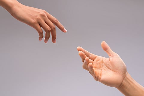 Two hands reaching to each other