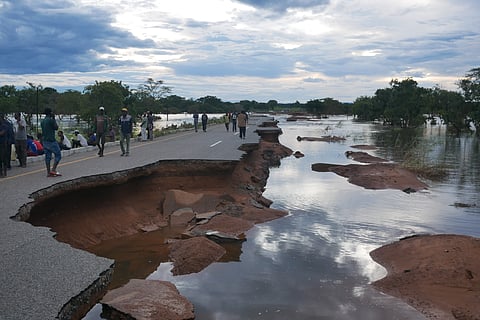 Mozambican villagers wait for help at a collapsed bridge after Cyclone Freddy
