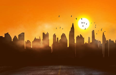 Silhouette of highrises in a city with a blazing sun