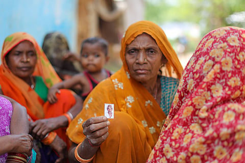 Basanti Gond showing a photograph of her husband Munni Lal, who died recently.