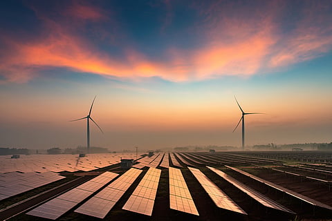 Solar power plants in the dusk of the evening with wind energy turbines in the background
