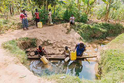 Family getting water from a well in Entebbe, Uganda