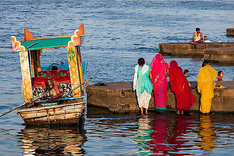 नर्मदा के पवित्र घाट पर पूजा करती महिलाएं; प्रतीकात्मक तस्वीर: आईस्टॉक