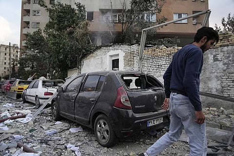 A man walks at the scene of an explosion in a residence compound in northern Tehran, Iran