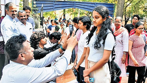 Higher Education Minister MC Sudhakar scans students who arrived for CET at a college in Bengaluru on Friday