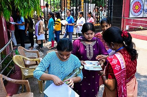 Candidates standing in queue for security check-up before appearing NEET exam at Hyderabad
