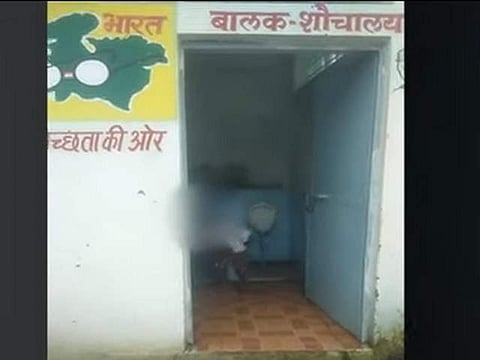 A videograb shows children cleaning toilets (Pic: Social Media)