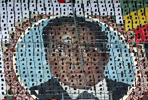 Zimbabwean children hold cards that make up a portrait of Robert Mugabe during the 25th anniversary of independence celebrations in 2005 (Pic: Howard Burditt/Reuters)