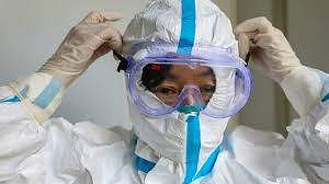 A doctor in Chennai putting on their PPE
