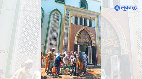 A cleric distributing water from Noorani Masjid
