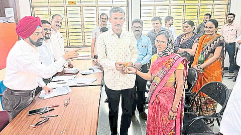 Malgegaon Civil District Judge Tejwantsinh Sandhu giving flowers to the couple at the district court to marry them. A lawyer next door.