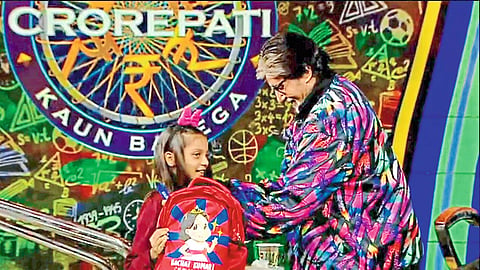 Megastar Amitabh Bachchan felicitating Surbhi Tripathi, a participant in the 'Kaun Banega Crorepati' program, with a gift.