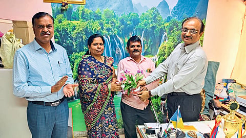 Insurance officer handing over Malaysia study tour letter to Divyang Nimba Sawant's wife Sunita Sawant.