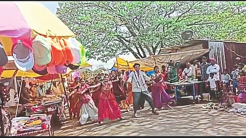 Performers dancing to the song in the Weekly market