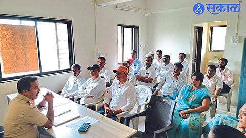 A police officer guiding a meeting of police teams at a police station.