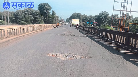 Potholes and dangerous protection rocks on the bridge over the river Dhaadi in the city.