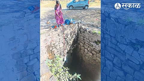 Women drawing water from a well in Audhainwadi settlement.