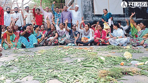 In front of the entrance of Rajiv Gandhi Bhavan, vendors throwing vegetables against the unfair action taken by the encroachment department against the vegetable vendors.