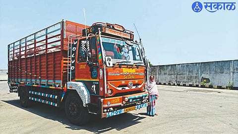 Ratnabai Patil standing with truck blocked at border check post.