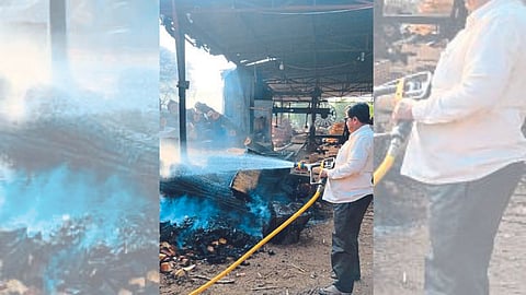 Workers dousing the fire in the woodshed here.
